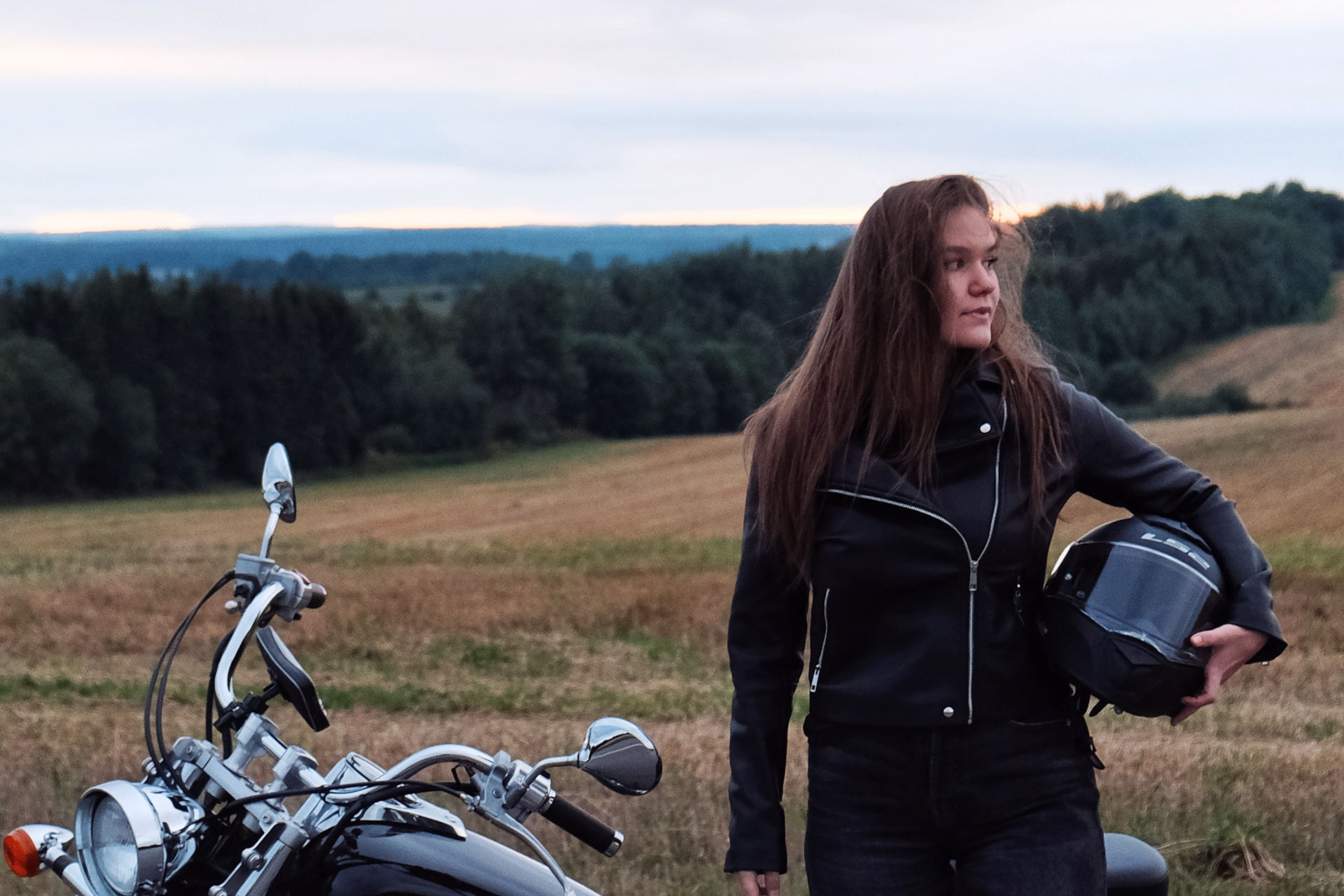 Femme portant un casque moto sous le bras