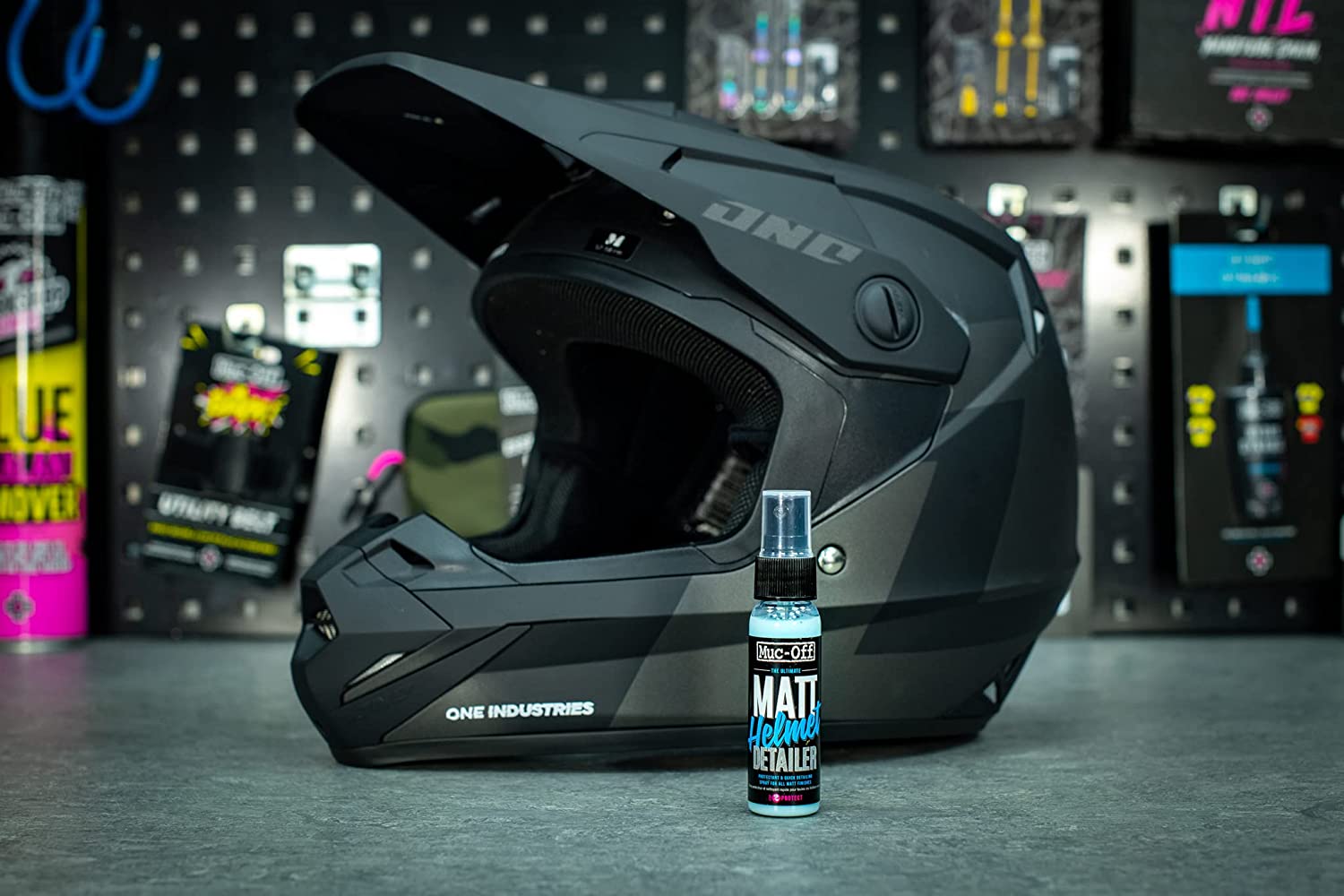 Casque motocross derrière un spray de produit nettoyant