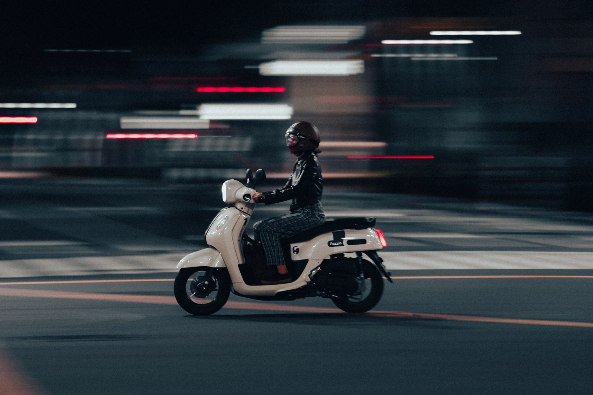 Scooter circulant sur route de nuit