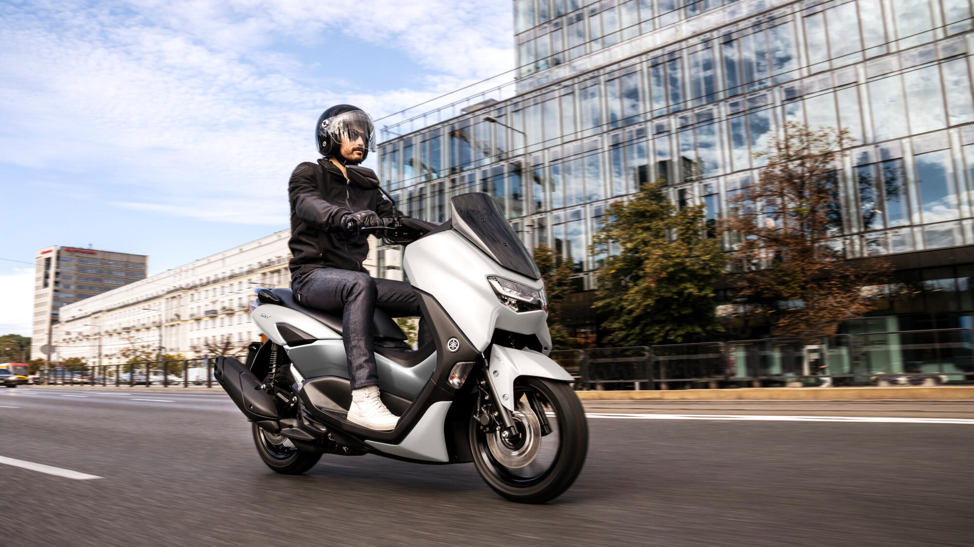 Scootériste en Yamaha N-Max 125 cm³ portant un casque jet