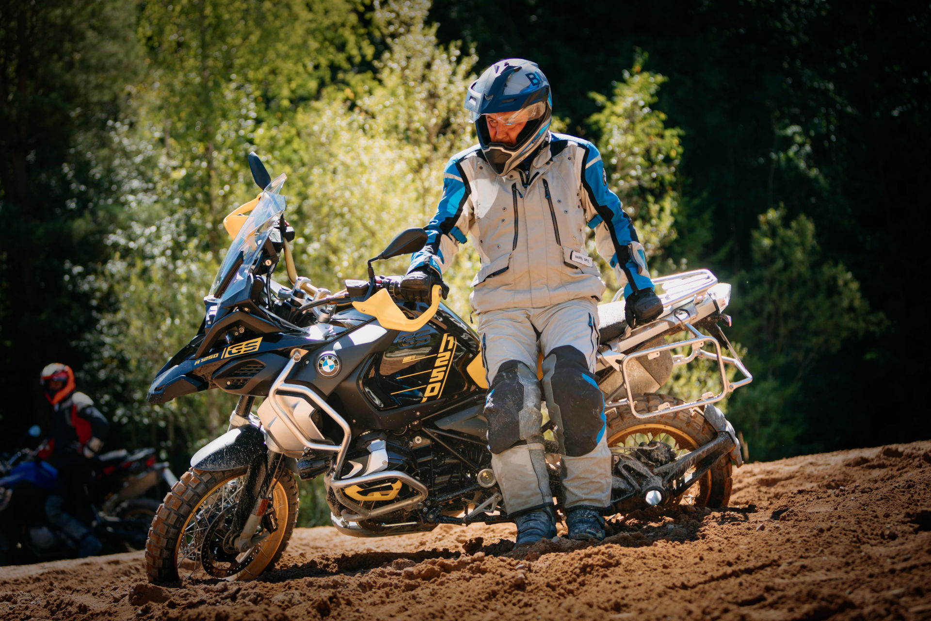 Motard équipé d'un casque adventure relevant son trail tombé au sol