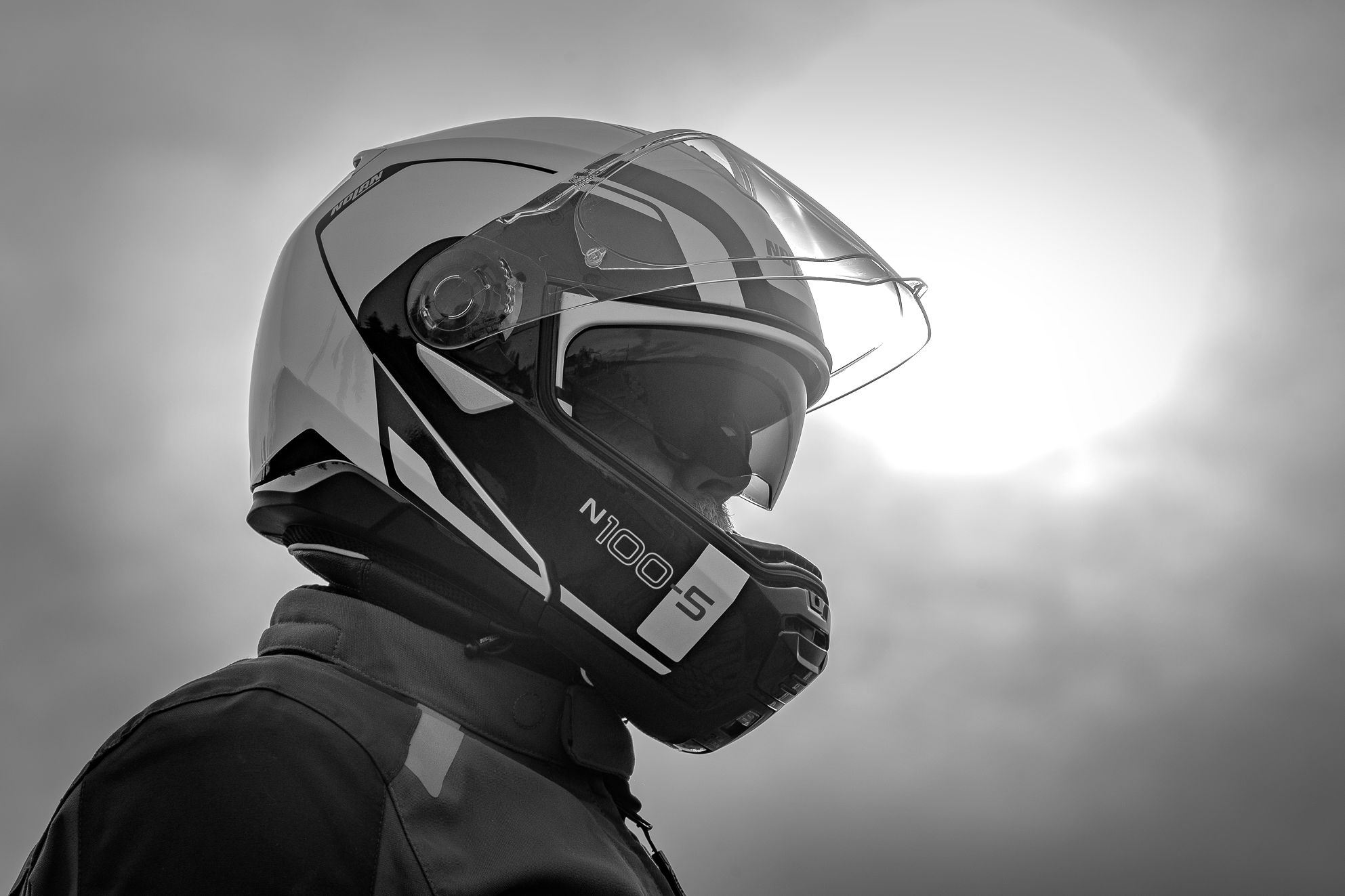 Casque modulable Nolan N100.5 avec écran solaire interne déployé et écran principal ouvert sur la tête d'un motard