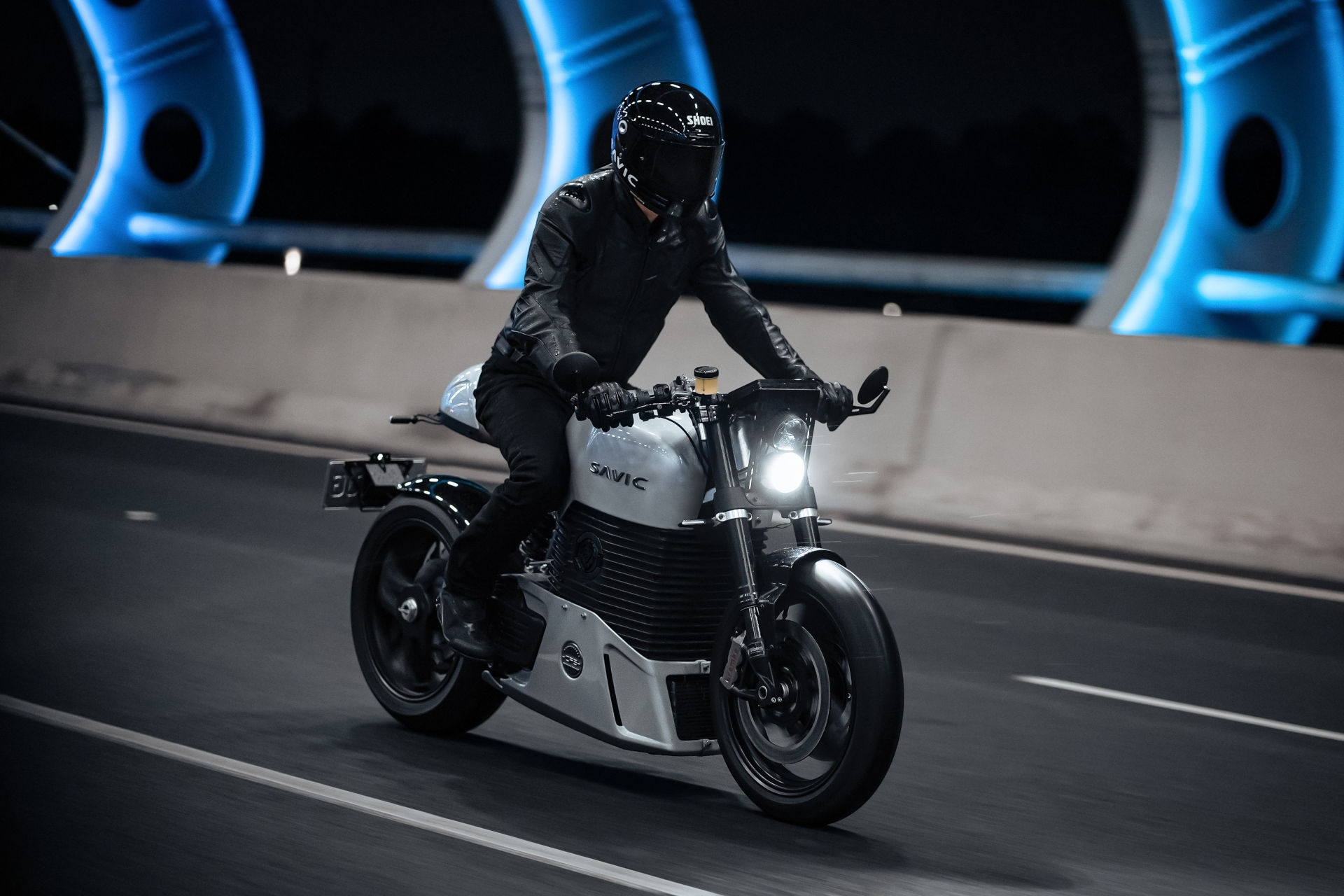 Motard circulant sur un roadster électrique portant un casque moto intégral