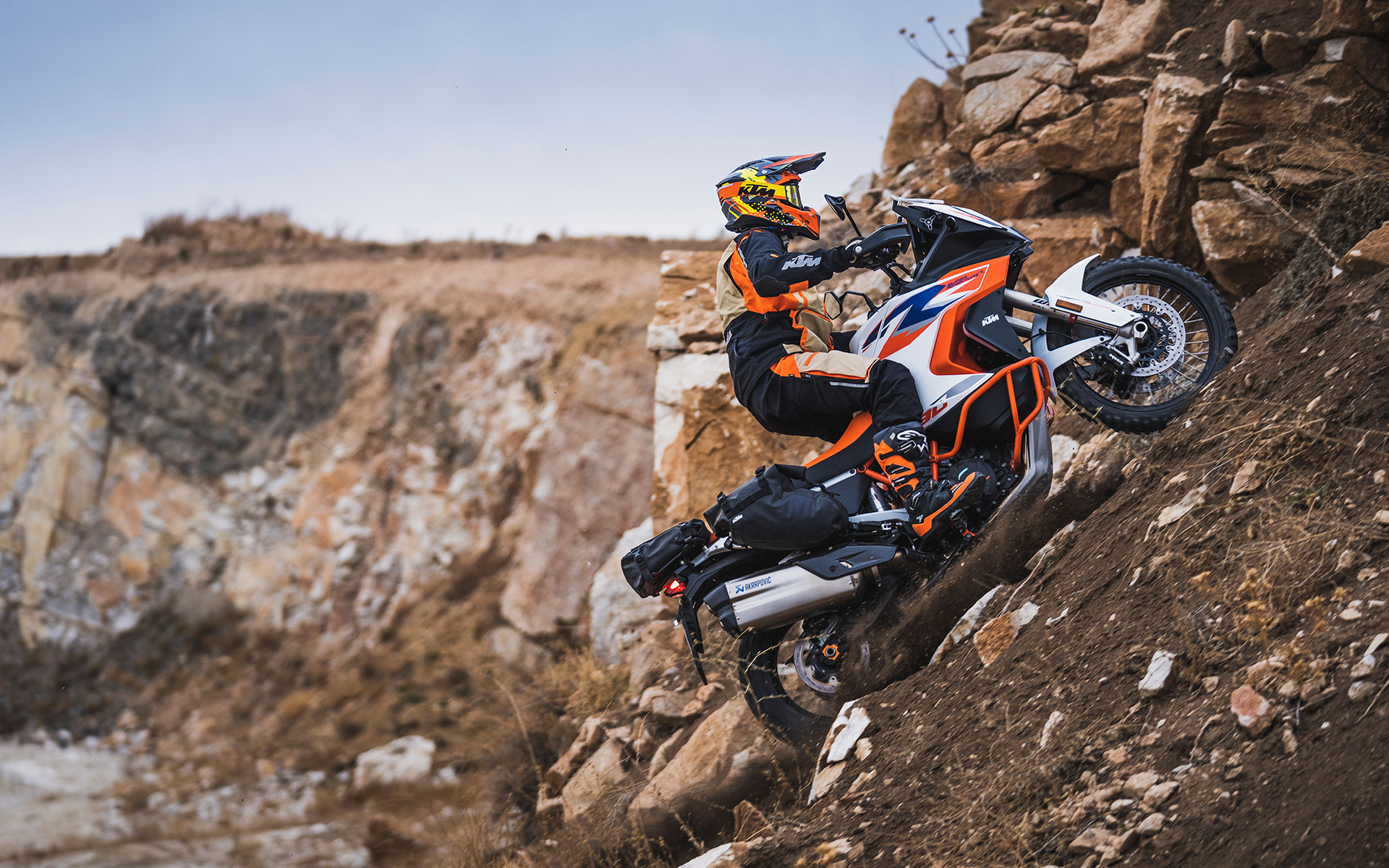 Un motards au guidon d'une KTM adventure en plein franchissement, portant un casque cross