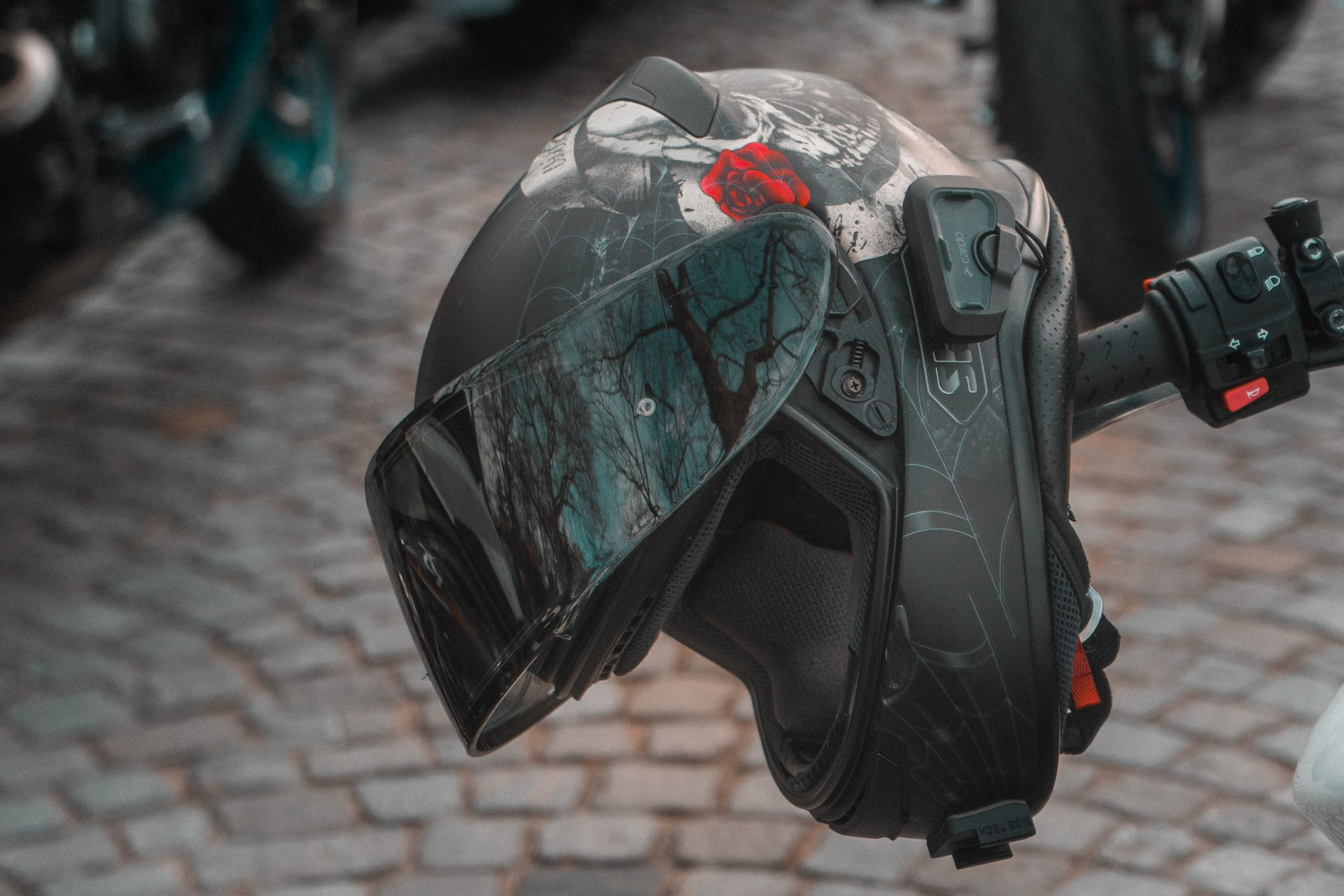 Casque intégral Shoei accroché au guidon d'une moto